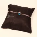 Filigranes, versilbertes Metall-Armband mit mittig platziertem Evil Eye (blaues Nazar-Auge) vor hellem Hintergrund.