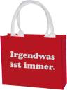 Rote Shoppertasche aus Polyester mit weißem Aufdruck „Irgendwas ist immer“ und stabilen Griffen.