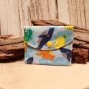 Kleiner handgenähter Geldbeutel von chic-peppig-bunt aus blauem Stoff mit Fisch-Motiv und bunt gestreiftem Innenfutter auf hellem Hintergrund.