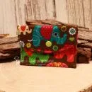 Kleiner handgenähter Geldbeutel von chic-peppig-bunt aus braunem Stoff mit bunten Elefanten und grünem Punkt-Futter auf hellem Hintergrund.