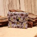 Kleiner handgenähter Geldbeutel von chic-peppig-bunt aus grauem Stoff mit Auto-Motiv und grün gepunktetem Innenfutter auf hellem Hintergrund.