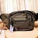Dunkelgrüne Gürteltasche mit drei Reißverschlussfächern auf der Vorderseite und verstellbarem Hüftgurt.
