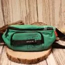 Vorderansicht der grünen Nylon-Gürteltasche mit dem weißen Aufdruck ADI und sportlichem Schriftzug.