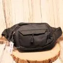 Schwarze Gürteltasche mit drei Reißverschlussfächern auf der Vorderseite und verstellbarem Hüftgurt.