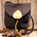 Flache graue Handtasche aus Filz mit aufgenähter weißer Calla-Blüte, schwarzem Innenfutter und langem Schulterband vor neutralem Hintergrund.