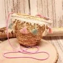 Kleine runde Korbtasche für Kinder aus naturfarbenem Rattan mit bunten Pastell-Quasten und Kordel-Schulterband.