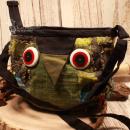 Grüne Umhängetasche Susi in Eulenform mit grünem Schnabel, bunten Patchwork-Details und verstellbarem Schultergurt.