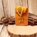 Gelbe handgenähte Utensilientasche aus Filz mit einer leuchtend gelben Gürtelschlaufe für den Hosenbund auf hellem Hintergrund.