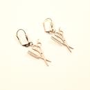 Handgefertigte Edelstahl-Ohrringe mit Kamm- und Scheren-Motiv an versilberten Klappbrisuren.