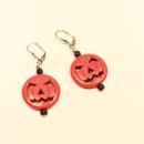 Handgefertigte Halloween-Ohrringe mit grinsender Kürbis-Perle, schwarzen Akzentperlen und versilberter Klappbrisur.
