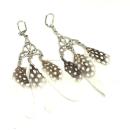 Lange versilberte Traumfänger-Ohrringe mit weißen Polka-Dot-Federn und praktischer Klappbrisur für Damen.