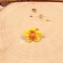 Handgefertigter gelber Filzring für Kinder in Blumenform mit orangefarbenen Akzenten auf verstellbarer Ringschiene.