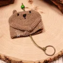 Gehäkelter Schlüsselanhänger Bär handmade in Grau mit grüner Perle als Taschenbaumler für den Online-Shop