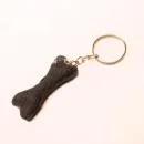 Handgefertigter Mini Knochen aus dunkelgrauem Filz als witziger Schlüsselanhänger und weicher Taschenbaumler, Gesamtansicht.