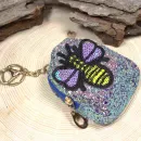 Glitzerndes Schlüsselanhänger Mäppchen in Bunt mit detailreichem Biene-Motiv, geschlossen, zur Verwendung als Mini-Utensilientasche oder Schlüsselorganizer.