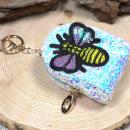 Glitzerndes Schlüsselanhänger-Mäppchen in Weiß mit Biene-Motiv und 17 cm Schlüsselring.