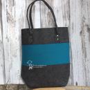 Große handgefertigte türkise Shoppertasche aus Filz mit stabilen Nieten an den Henkeln auf hellem Hintergrund.