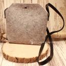 Hellgraue Handtasche aus Filz mit braunem Lederriemen und silbernem Druckknopf-Verschluss in minimalistischem Design.