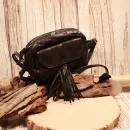Kleine schwarze Umhängetasche aus Leder mit zwei dekorativen Quasten am Magnetverschluss und verstellbarem Schulterriemen.